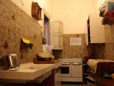 ...e un'angusta cucina in cui sono quasi incastrati un lavandino, il forno e un paio di mobiletti per le stoviglie